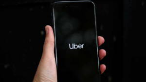 Aplicativo do Uber aberto em celular na mão de uma pessoa