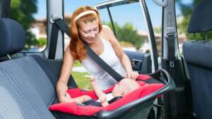 Criança de colo em cadeirinha dentro do carro