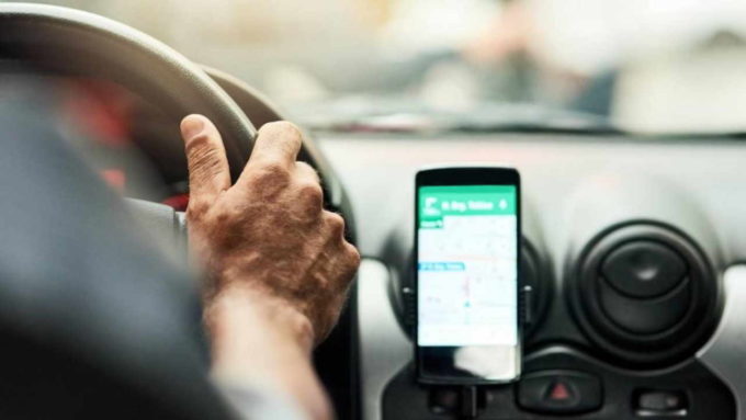 Motorista com GPS aberto no celular