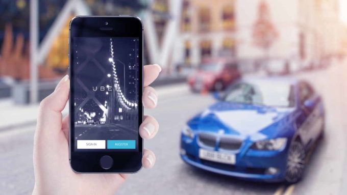 Mulher segurando celular com app Uber aberto