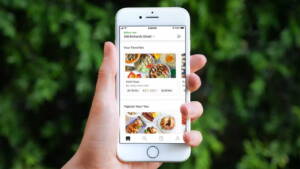 Pessoa segurando celular com app Uber EATS aberto