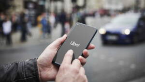 Segurando o celular nas mãos com logo do Uber aberta