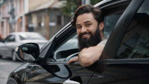 Motorista sorrindo na porta do carro