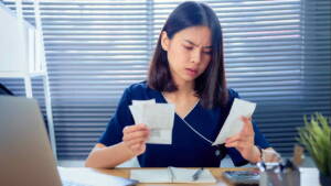 Mulher analisando cupons fiscais