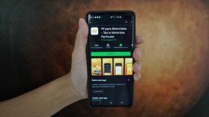 Segurando celular com Google Play aberta no app 99 para motoristas