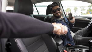 Motorista segurando a mão de passageiro
