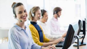 Mulher sorrindo enquanto realiza atendimento por telefone